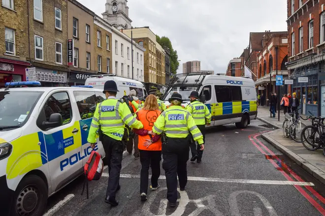 Police officers arrest an environmental protester during a demonstration