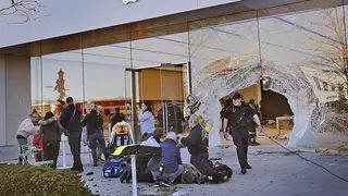 Emergency workers help injured shoppers after a car drove into an Apple store in Hingham