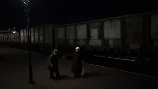 Two elderly women walk towards the Kyiv train at Kherson station