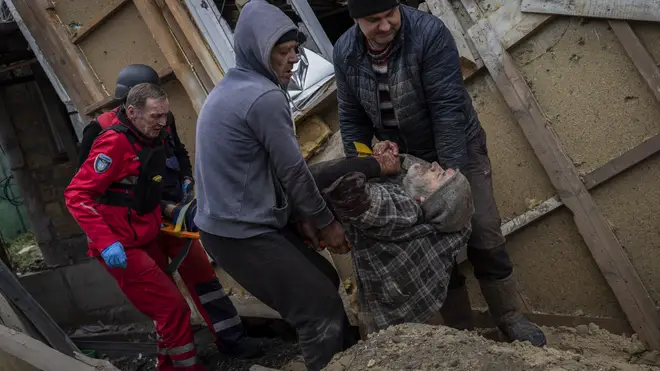 Neighbours and paramedics evacuate Viktor Anastasiev to a hospital after he was injured during a Russian strike in Kherson, southern Ukraine on Thursday