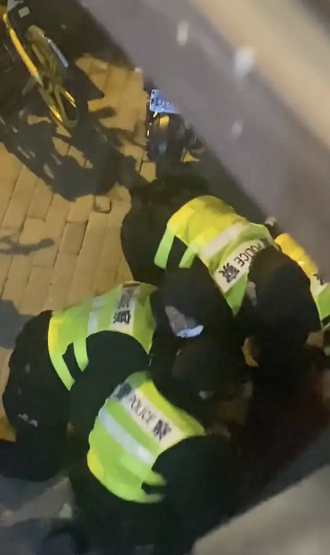 Police were seen pinning the cameraman to the ground
