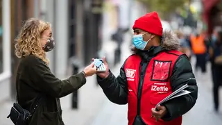 A Big Issue vendor takes a contactless card payment