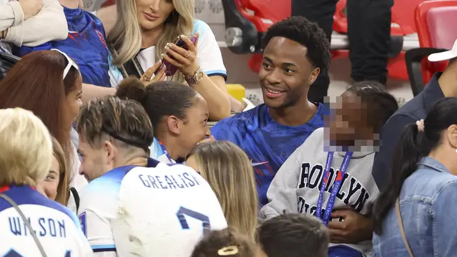 Sterling holds one of his three children after the match against Wales