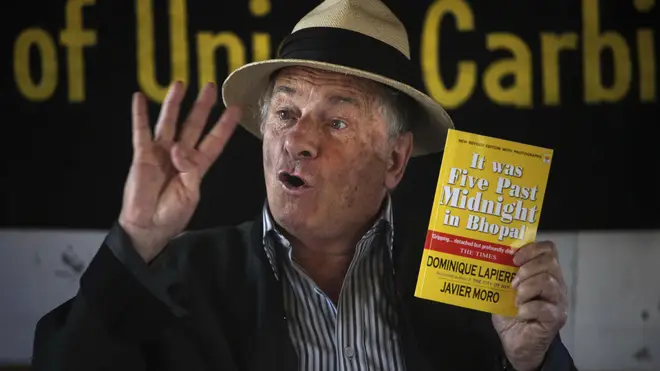 French writer and activist Dominique Lapierre holds a copy of his book on the Bhopal gas tragedy, in Bhopal, India, in 2009