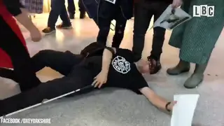 A blind vegan activist is on the floor.