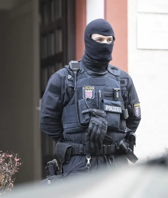 Police officers stand by a searched property in Frankfurt