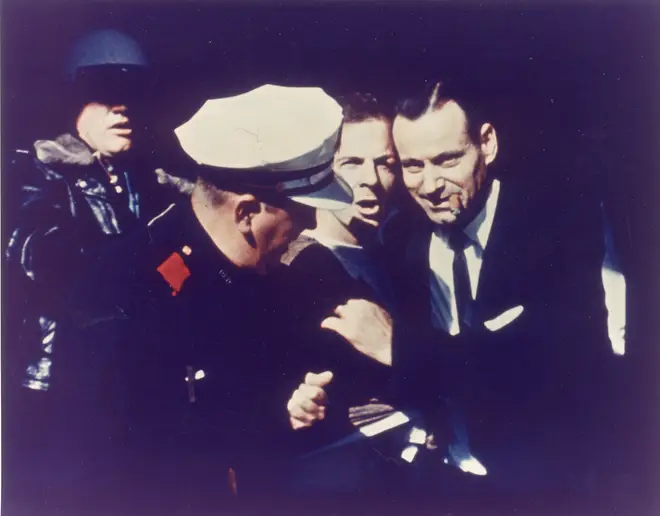 Lee Harvey Oswald being escorted by police