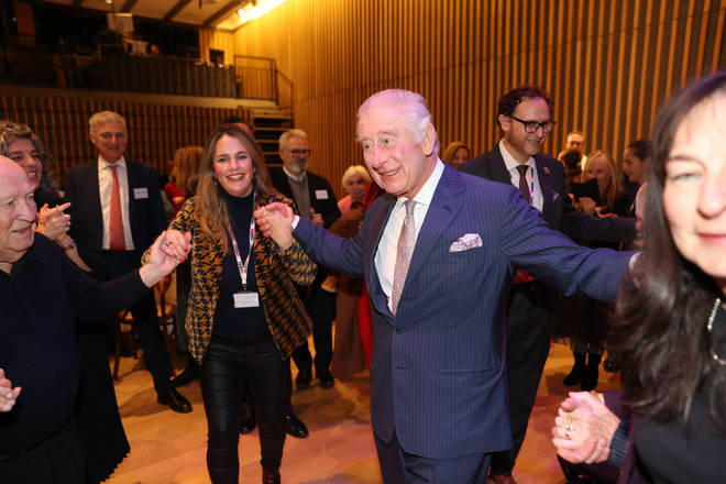 King Charles smiles as he danced with well-wishers at the community centre