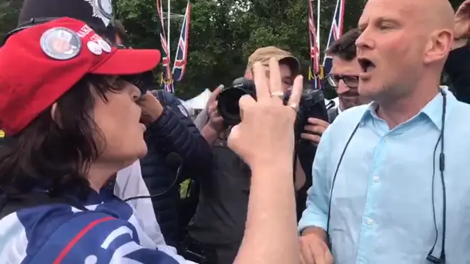 A woman wearing a Make America Great Again hat argues with an anti-Trump protester