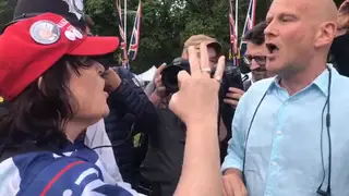 A woman wearing a Make America Great Again hat argues with an anti-Trump protester