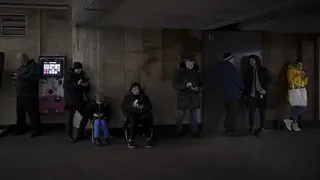 People use their phones while they gather in a metro station during an air raid alarm in Kyiv, Ukraine