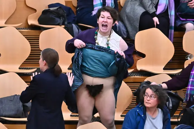 Protester Elaine Miller reveals genital area in the public gallery of the Scottish Parliament