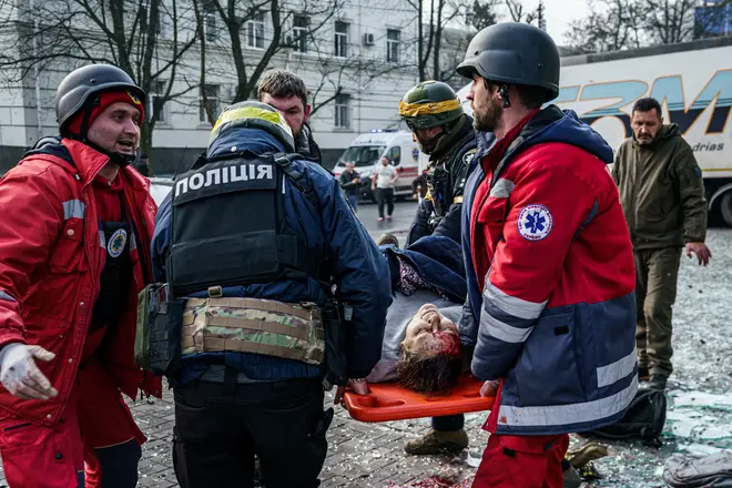 Rescuers carry an injured woman on a stretcher