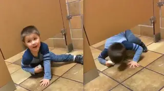 Child crawls under public toilet door