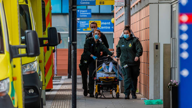 A patient is brought in on a trolley with a police escort