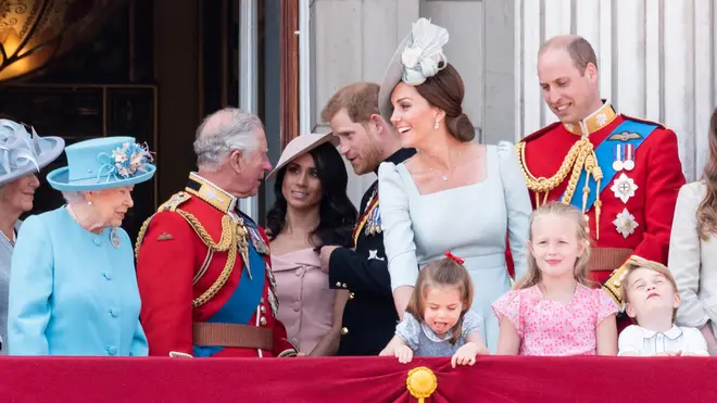 Then-Prince Charles talks with Harry and Meghan on the balcony at Buckingham Palace as the Queen and the Cambridges watch on