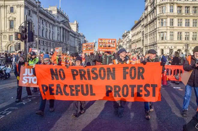 Protesters march in Parliament Square with a 'No prison for...