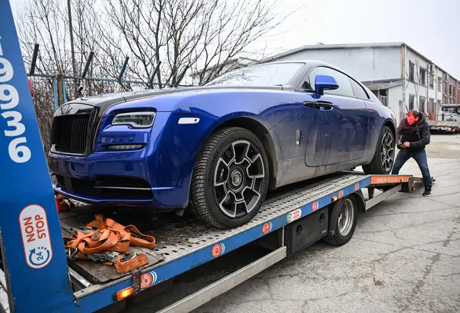 Police transport a Luxury car on a platform out from Tate's home on January 14, 2022.