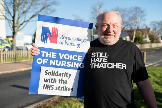 A Member of Save Southend NHS group wearing a T-shirt saying "Still Hate Thatcher" holds a placard in support of RCN strikes across the country