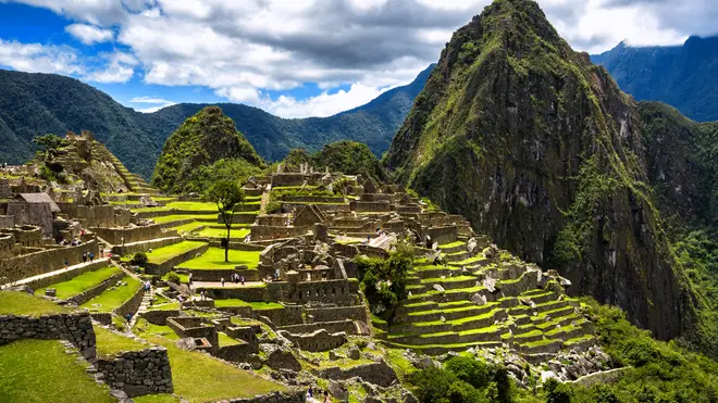 View of the Lost Incan City of Machu Picchu near Cusco, Peru. Machu Picchu is a Peruvian Historical Sanctuary. People can be seen on foreground.