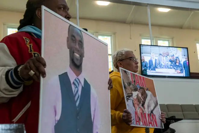 Activists hold signs showing Tyre Nichols as Ben Crump, an attorney representing the Nichols family is seen speaking on a monitor during a press conference at Mt. Olive Cathedral CME Church, January 23, 2023.