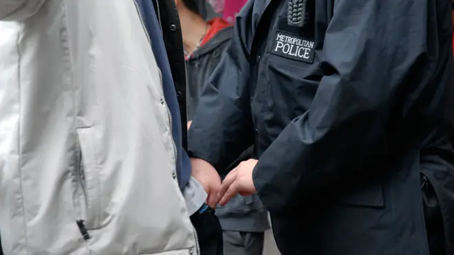 A police officer carries out a stop and search operation in London