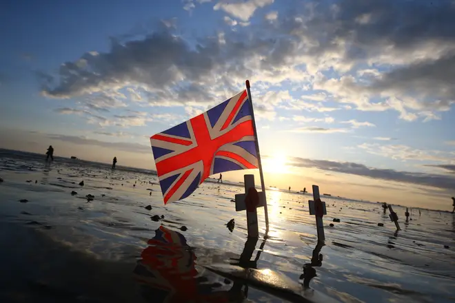 Crosses of remembrance placed alongside a Union flag stand at dawn on the beach at Arromanches in Normandy, northern France, ahead of a day of events to mark the 75 anniversary of D-Day.