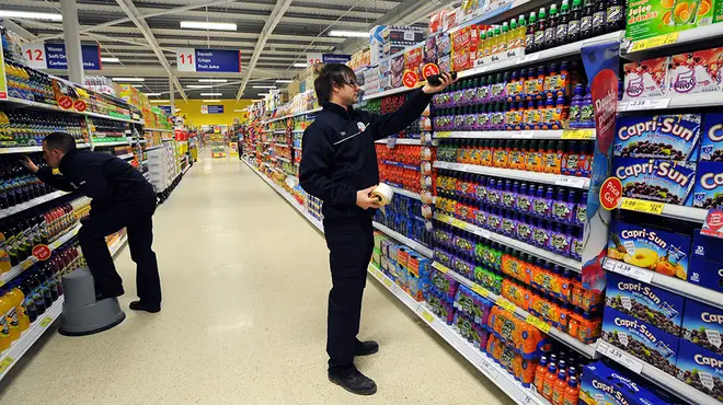 Tesco managers stocking shelves in store