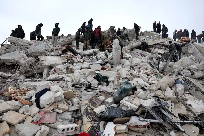 Residents and rescuers search for victims and survivors amidst the rubble of collapsed buildings following an earthquake in the village of Besnaya in Syria's rebel-held northwestern Idlib province on the border with Turkey, on February 6, 2022.