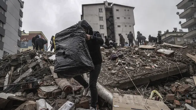 People and emergency teams search for people in the rubble in a destroyed building in Gaziantep