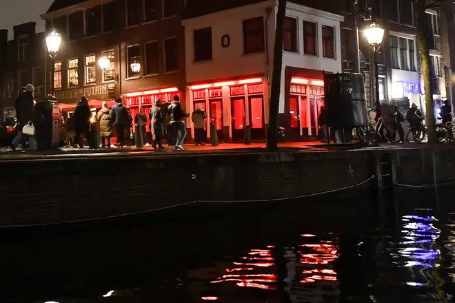 People walks near of red Light inside the Red Light District on December 10, 2022.