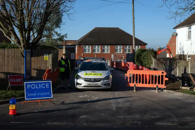 A police car is parked at an entrance to Epsom College after the school's head, Emma Pattison, was found dead alongside her family