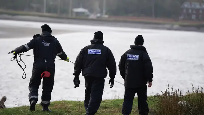 Police search teams on the banks of the River Wyre