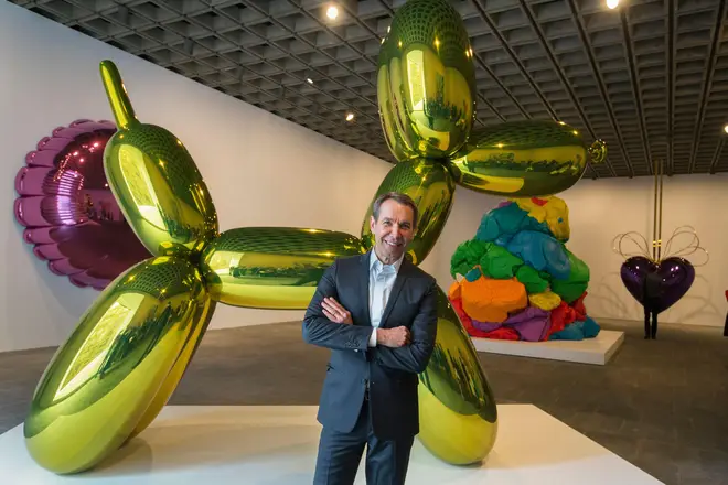 Jeff Koons in front of another of his balloon dog sculptures before the opening of his retrospective at the Whitney Museum of American Art in New York June 24, 2014.