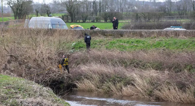 Police search a section of the river where the body was found