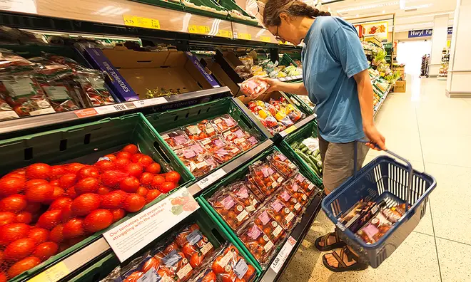 Shopper buying tomatoes in supermarket