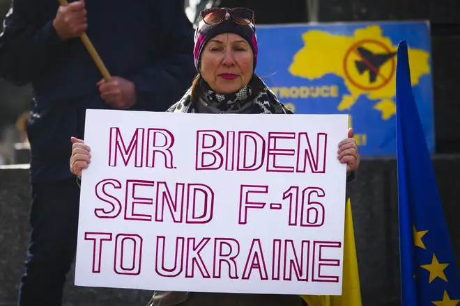 A woman holds a banner 'Mr Biden Send F-16 To Ukraine' during a daily demonstration of solidarity with Ukraine
