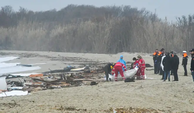 Recuers handle a body bag at the site of the shipwreck in Steccato di Cutro, south of Crotone,