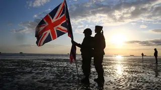 Military reenactors carrying the British flag