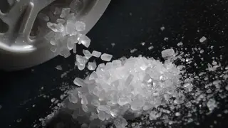 Sea salt is poured from a salt shaker