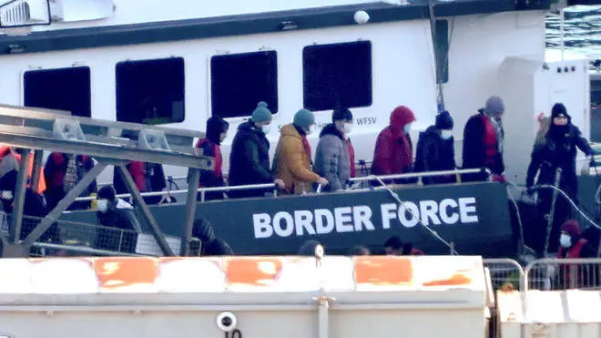 Migrants are pictured being escorted into the port of Dover