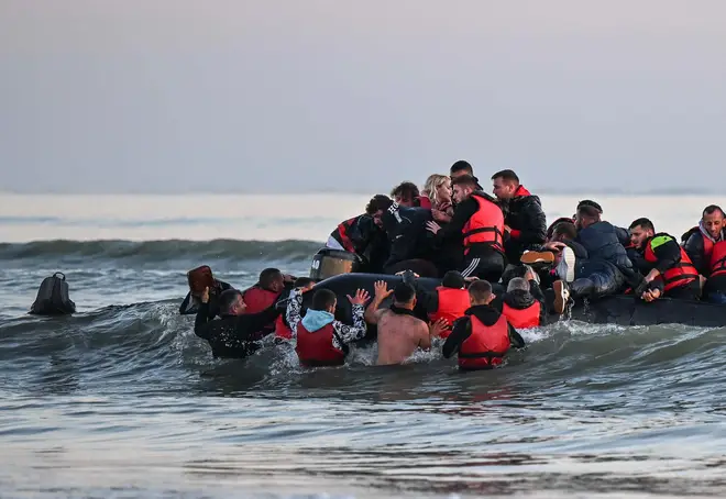 Migrants trying to board a small boat to cross the English Channel