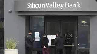 People look at signs posted outside an entrance to Silicon Valley Bank in Santa Clara, California