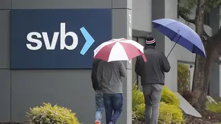 People walk past a Silicon Valley Bank sign at the company's headquarters in California