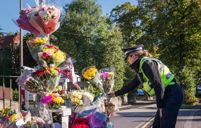A police community support officer lays a floral tribute at the scene in Woodhouse Hill, Huddersfield, where 15-year-old schoolboy Khayri McLean was fatally stabbed outside his school gates. Picture date: Friday September 23, 2022.