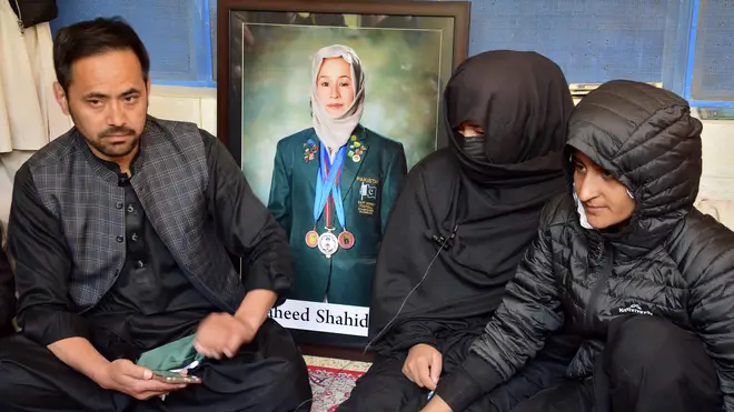 Sister Sadia Raza, centre, relative Naimatullah Hazara, left, and friend Sumiaya Kianat of female field hockey player Shahida Raza, who died in a boat accident, attend her funeral, in Quetta, Pakistan