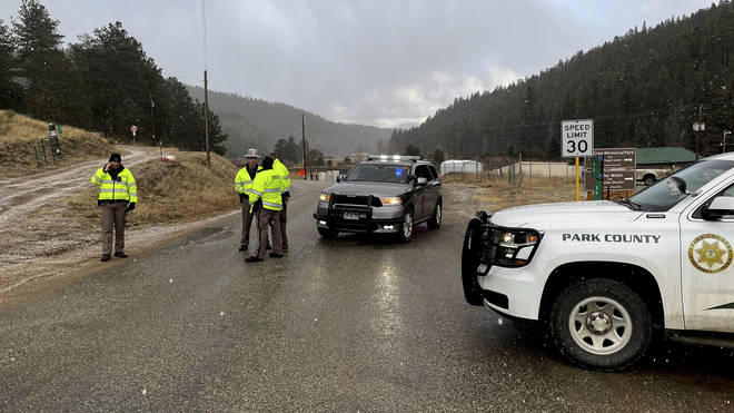 Authorities block a road in the town of Bailey, Colorado, wher<em></em>e authorities found an abando<em></em>ned car belo<em></em>nging to the suspect in a shooting of two administrators at a Denver school