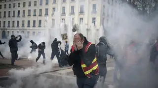 Protesters run amid the tear gas during a demonstration in Lyon