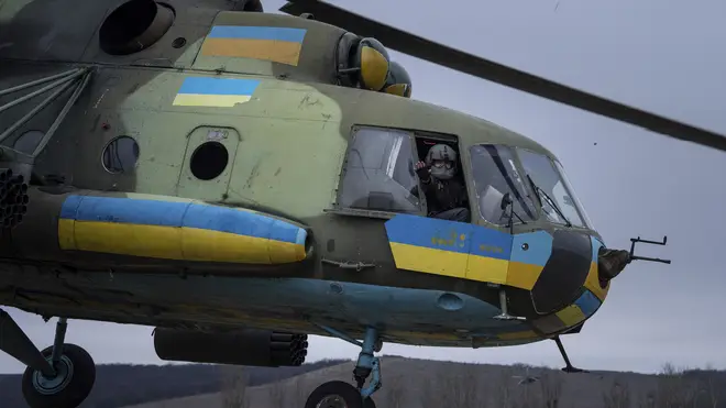 A Ukrainian pilot waves to his comrades from an Mi-8 combat helicopter during a combat mission in Donetsk region, Ukraine