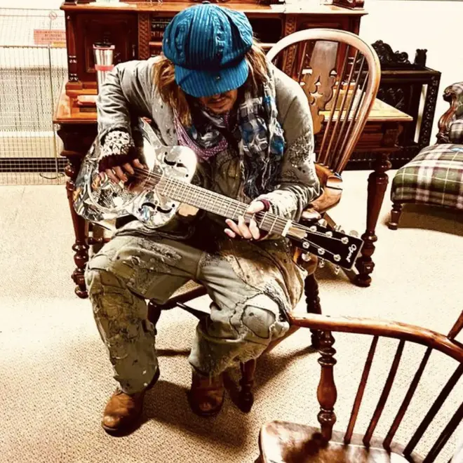 Depp plays a guitar at the antique shop